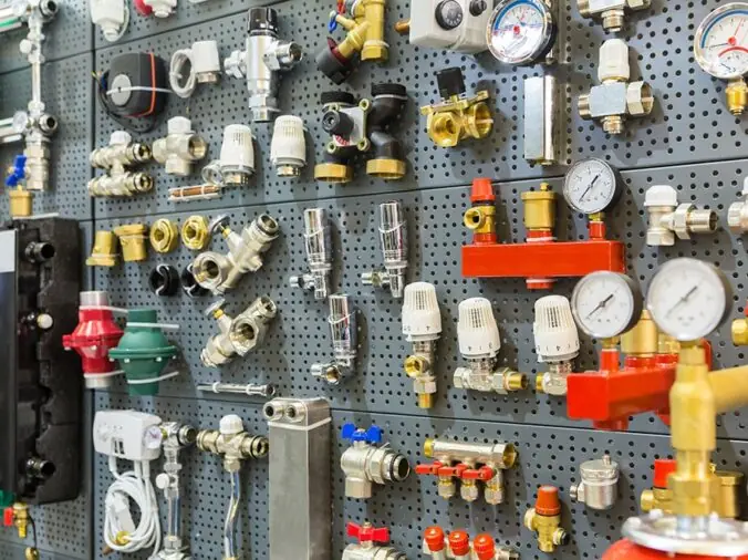 Brass and stailess plumbing valves and fittings on a wall in a plumbing supply store