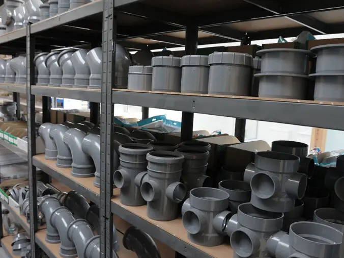 PVC elbows and junctions on shelf in a plumbing supply warehouse
