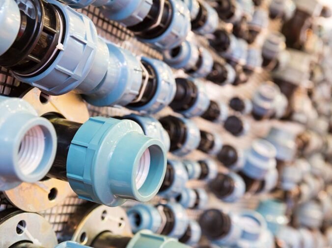 PVC union fittings on wall in plumbing supply warehouse